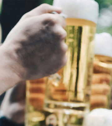 Mann hält ein Bier